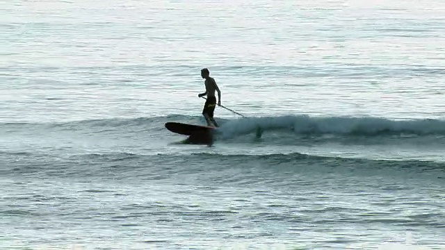 年轻人在冲浪板上冲浪视频下载