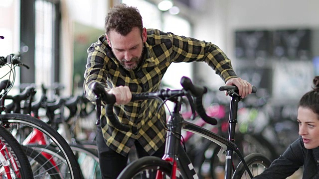 小企业主帮助客户在自行车商店视频素材