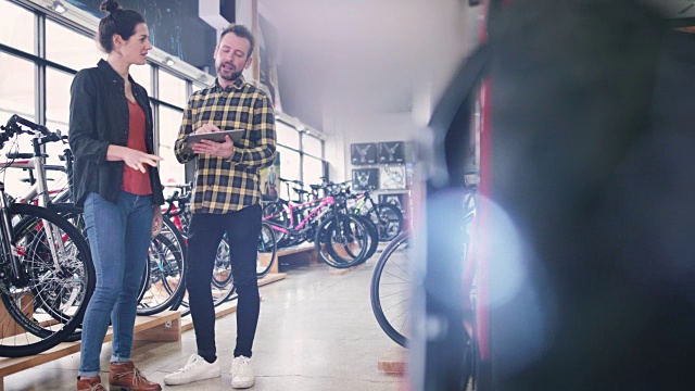 小企业主服务客户在自行车商店视频素材