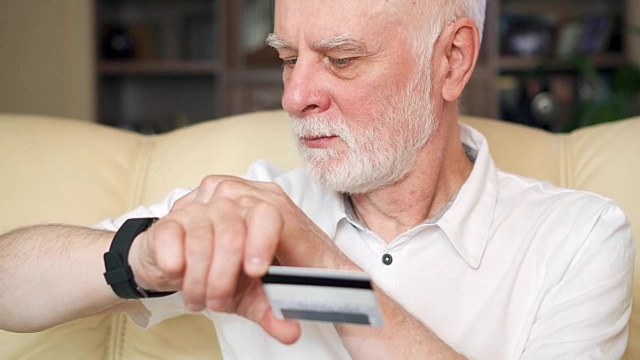 老人在家用智能手表刷卡在线购物。老年人使用的技术视频素材
