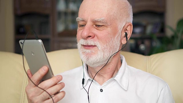现代老年人在智能手机上听音乐。退休美眉随着音乐跳舞视频素材