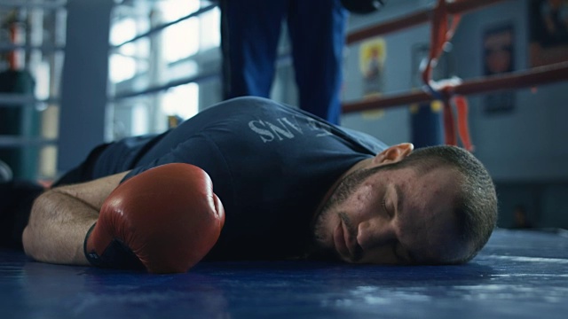 一名昏迷的拳击手戴着手套躺在戒指上视频素材