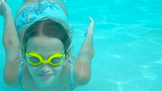 小女孩在游泳池的水下微笑着视频下载