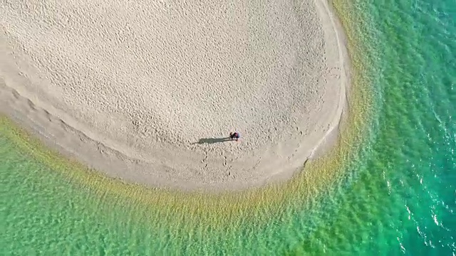 鸟瞰图夫妇飞行无人机，在博尔-兹拉特尼鼠，布拉克岛，克罗地亚阳光明媚，宁静的海滩视频下载