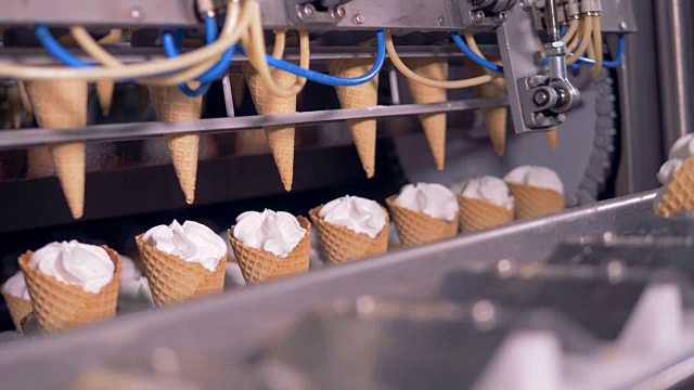 冰淇淋甜筒正从旋转式传送带转移到线性传送带视频素材