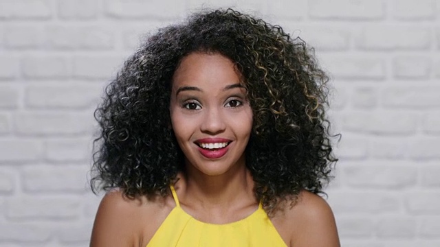 《砖墙上年轻黑人妇女的面部表情》视频素材