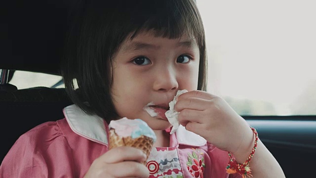 泰国小女孩在汽车旅行中吃冰淇淋视频素材