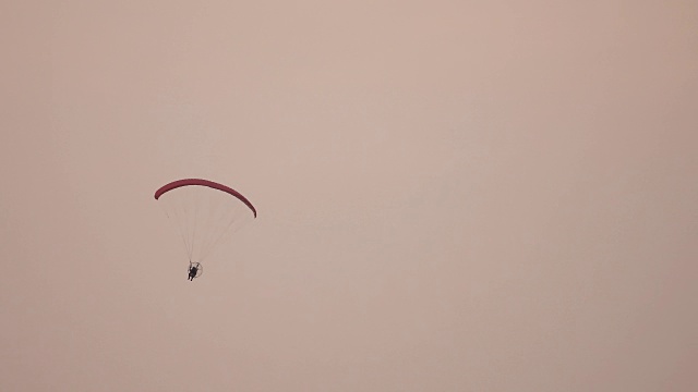 在灰色背景上远距离拍摄滑翔伞或滑翔伞。视频素材