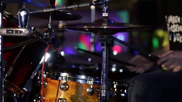鼓手在黑暗的彩色背景上在摇滚音乐会上打鼓。视频素材