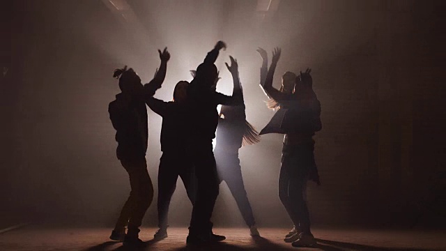 一群街头舞者在黑暗的街道上表演不同的动作视频素材