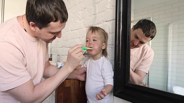 爸爸正在给儿子刷牙蛀牙视频素材
