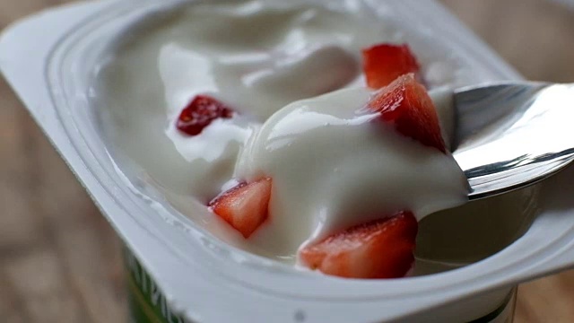 切碎的草莓放在一碗白色的天然酸奶里视频下载