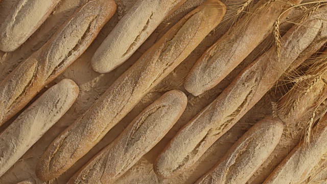 面包、面粉和小麦的完美组合。面粉慢镜头落到面包上。视频下载