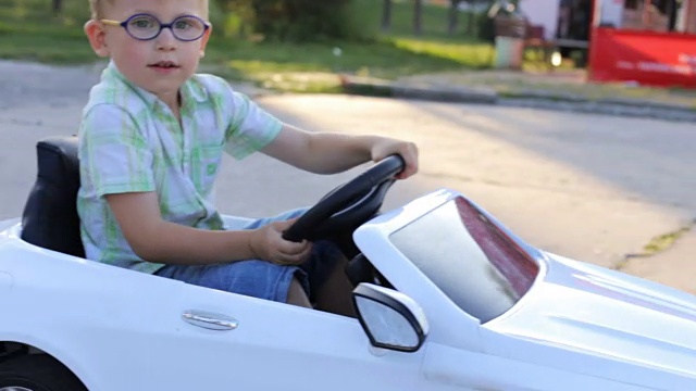 一个男孩正在骑儿童电动汽车视频素材