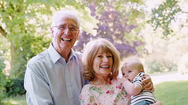 微笑的老夫妇和小孙子在户外的肖像视频素材