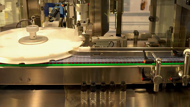 工业用机器人，用于在装有螺纹密封盖的瓶子中分配药物视频素材