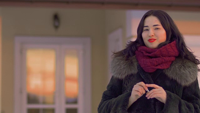 迷人的黑发和红唇从她的新房子摇钥匙视频素材