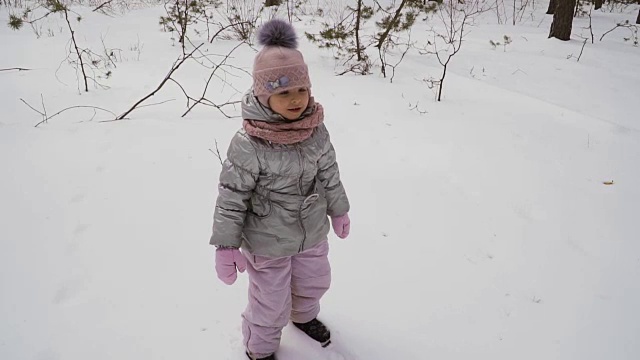 可爱的小女孩摔倒在雪地上，慢镜头视频下载