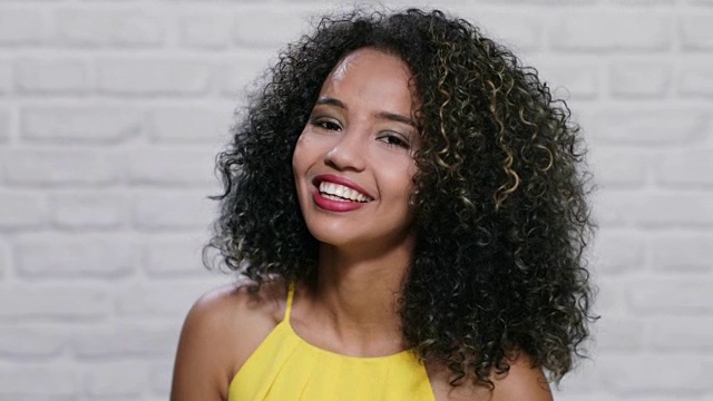 《砖墙上年轻黑人妇女的面部表情》视频素材