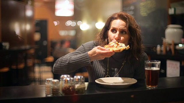 晚上在城市里，一个男人和一个正在吃披萨和喝啤酒的女人打招呼视频下载