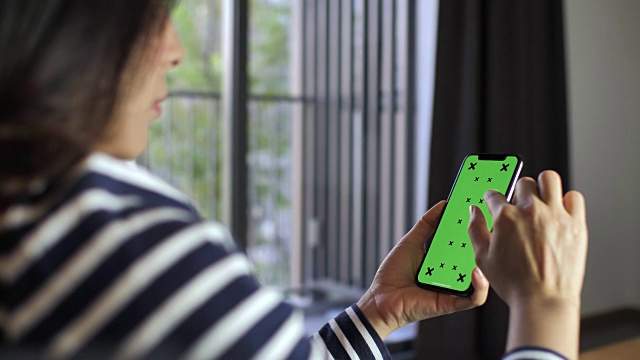 在家里使用智能手机绿色屏幕的女性视频素材