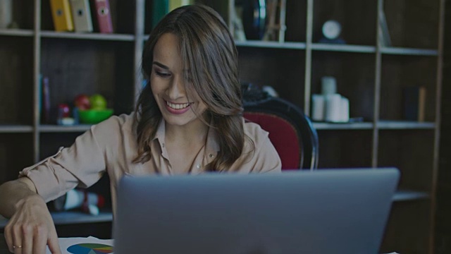 严肃的商务女性在办公室用笔记本电脑工作时微笑视频素材