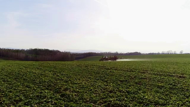 农用拖拉机向农田喷洒化学肥料。视频素材