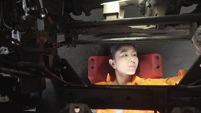 小车俯视图:亚洲年轻女性汽车机械师，研究汽车发动机视频素材