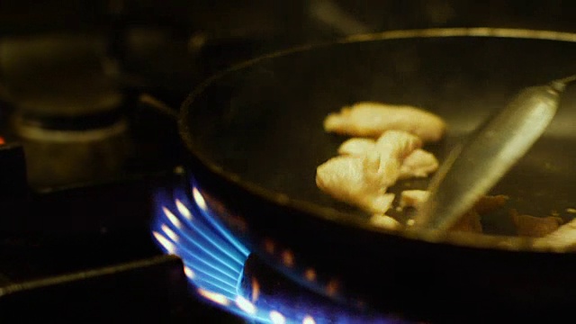 厨师在餐厅厨房的炉子上用平底锅煮鸡肉饭视频素材