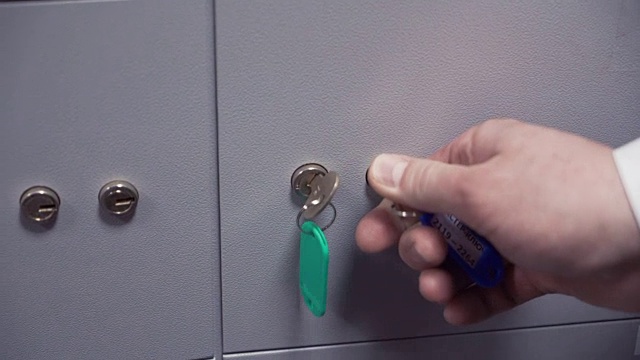 两个人用两把钥匙将保险箱锁上视频素材