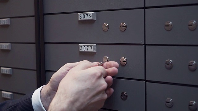银行经理与客户老人用两把钥匙关闭了保险箱视频素材