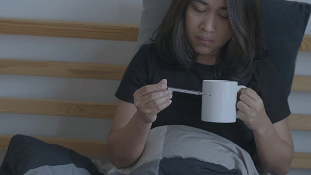 生病的女人在喝热茶。视频下载