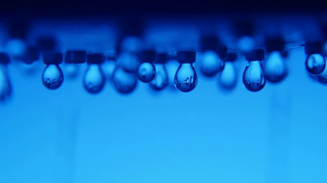 在一个现代的蓝色浴室里，闪亮的水滴从金属喷雾器中流出视频下载