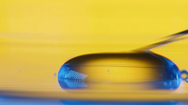 在实验室里，一根细针靠近并从玻璃上的水坑中吸取水视频下载