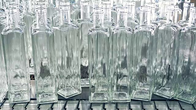 一堆新制作的透明瓶子被推到传送带上视频素材