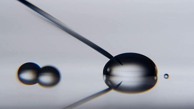 在科学实验室里，水晶水滴碰到金属针就变大了视频下载