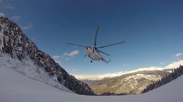 一架直升机降落在山上搭载滑雪者。视频下载