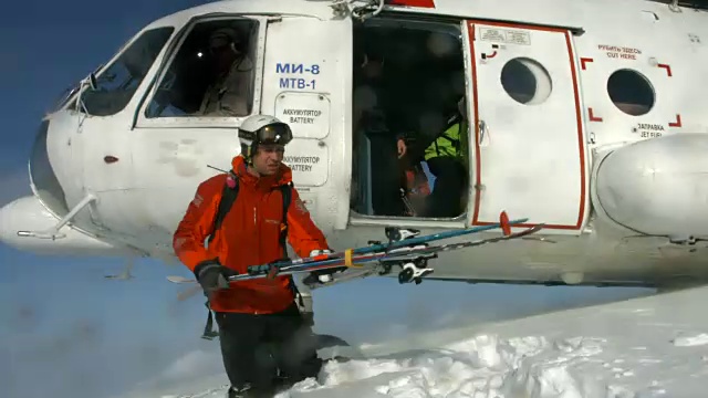 直升机在山上卸载滑雪者和滑雪板运动员。——延时视频下载