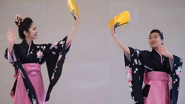 两个艺妓穿着传统的日本和服与扇子跳舞视频素材