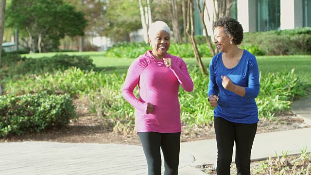 两个非裔美国女性快步走着，朋友路过视频素材