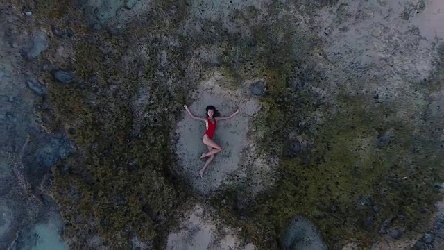 美丽的年轻女子躺在巴厘岛海滩的沙滩上视频素材