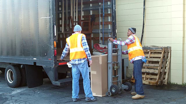 两名工人正在把大箱子装上卡车视频下载