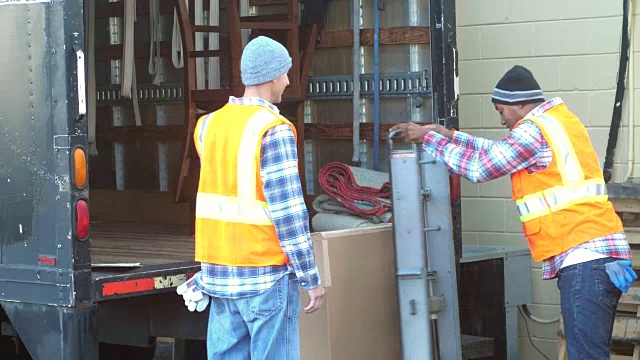 两名工人正在把大箱子装上卡车视频下载
