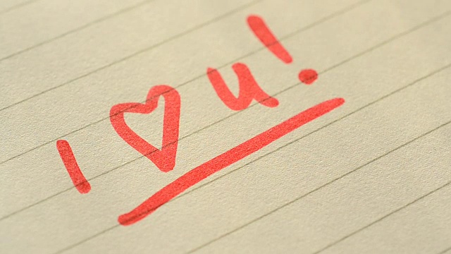 用红色记号笔在横格纸上手写“我爱你”视频下载