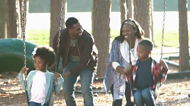 非裔美国家庭在操场上玩秋千视频素材