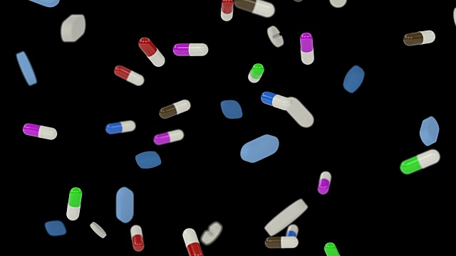 许多彩色药丸以极慢的动作落在黑色背景下视频素材