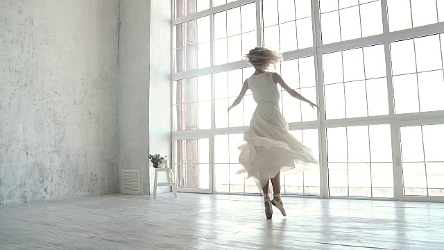 穿着轻薄裙子和尖头鞋的芭蕾舞女演员正踮着脚尖旋转。慢动作视频素材