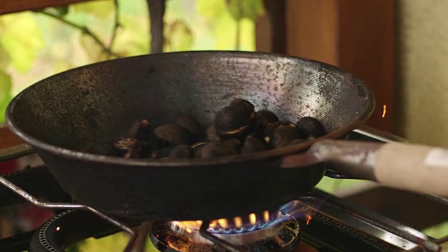 板栗在铁锅里火上烘烤，动作缓慢视频下载