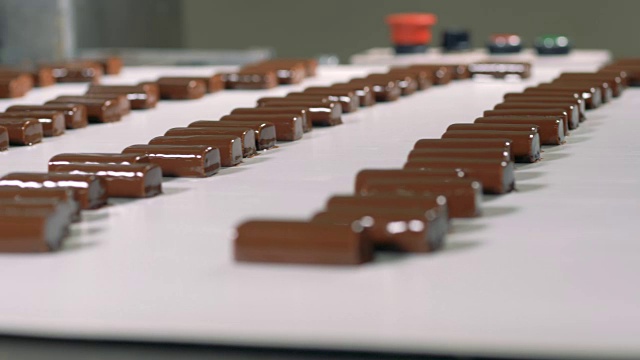巧克力糖果正在糖果工厂的传送带上运输。视频下载