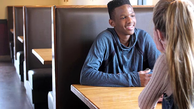 跨种族的青少年情侣在餐厅聊天视频素材